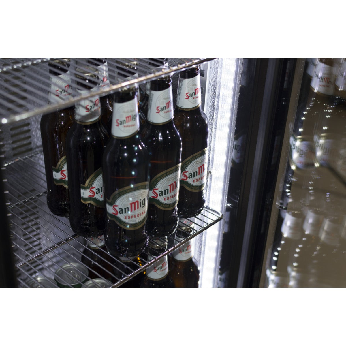 Interior view of the Prodis low energy single door bottle cooler, with bottled beers stored on wire shelves and bright internal LED lighting