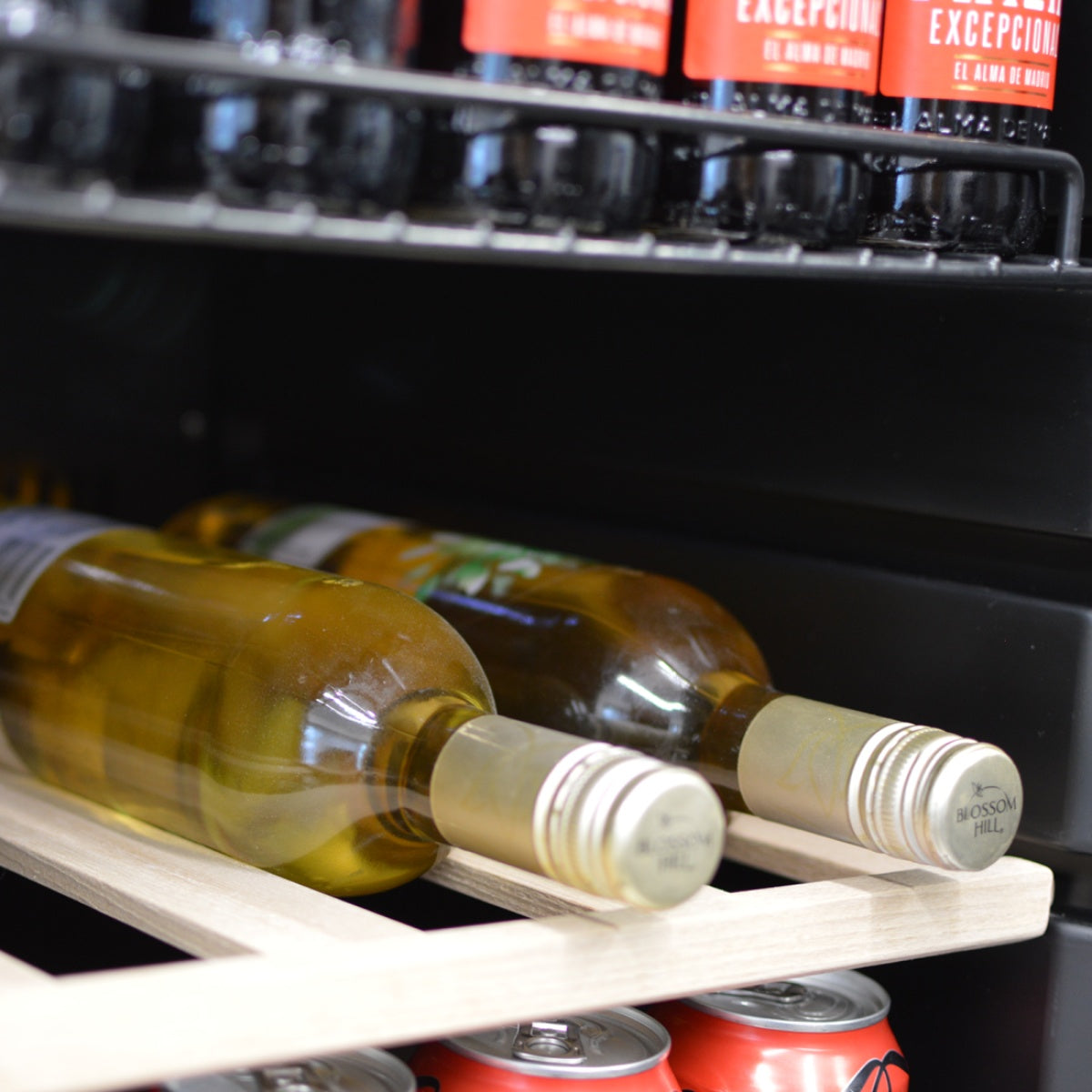 Close-up of bottled drinks stored inside the Prodis under counter beverage cooler, highlighting wine shelves and clear visibility through the glass door