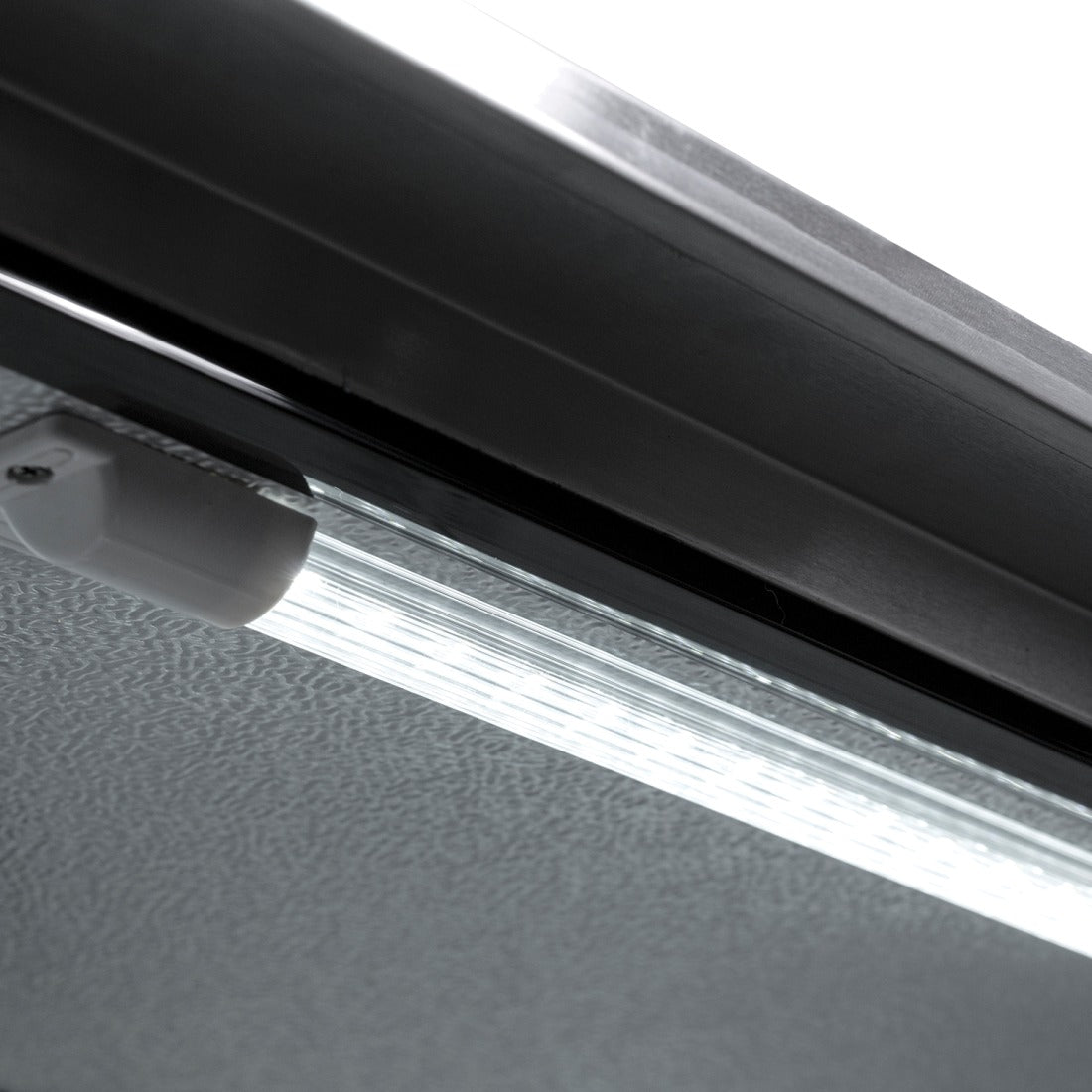 Interior LED lighting inside Prodis triple door bottle cooler illuminating adjustable chrome shelves and aluminium lining.
